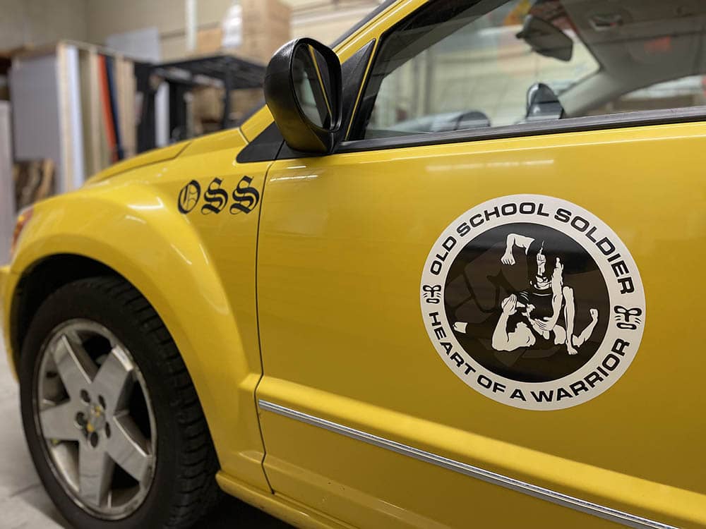 Vinyl decal on the side of a yellow vehicle for a martial arts company